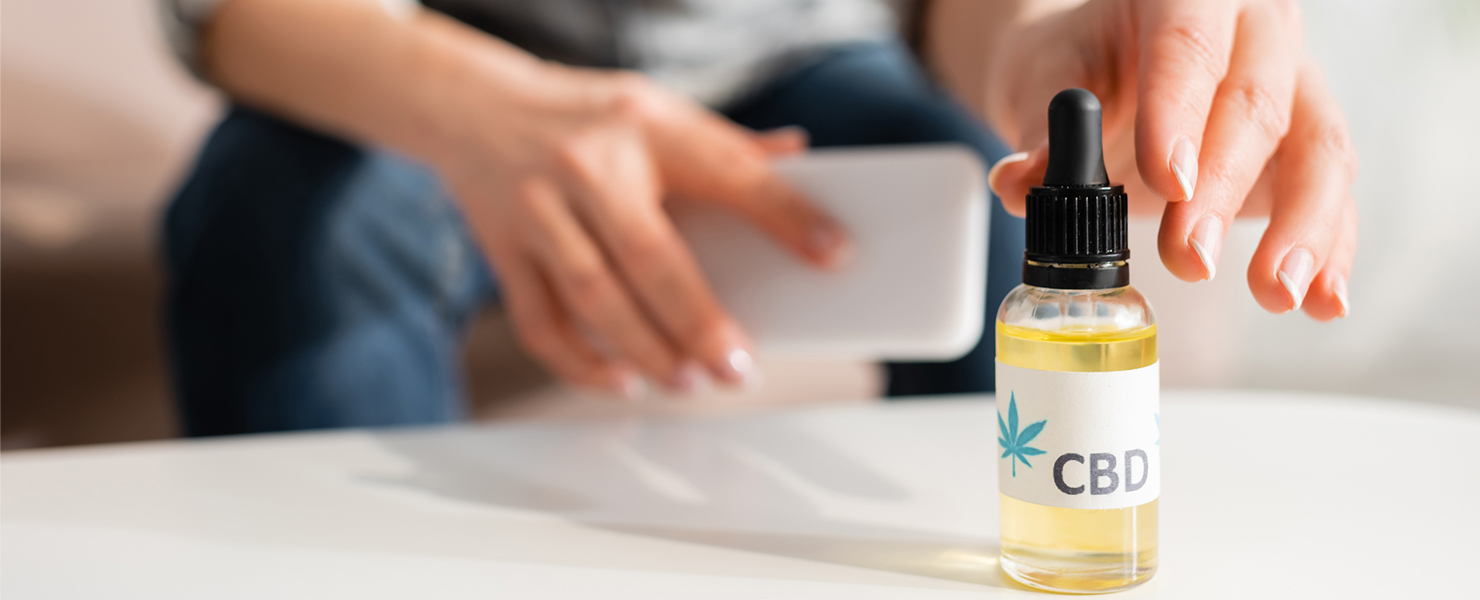 person holding cell phone and reaching for a cannabis product