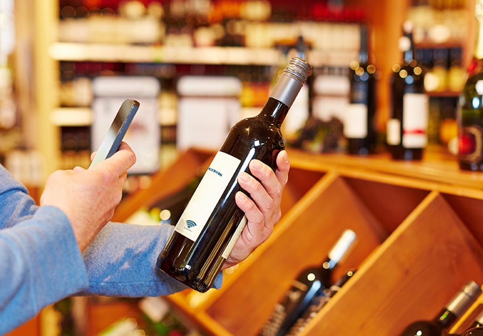 Man scanning NFC smart label on wine bottle