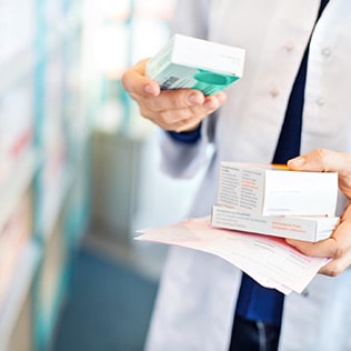 A pharmacist reads from a package