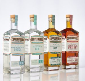 Four Copperworks whiskey bottles with custom labels