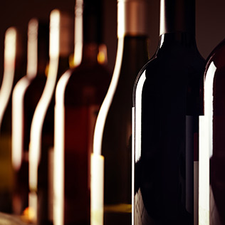 Darkly lit wine bottles in a row