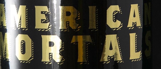 A foil label with gold lettering over a black background.