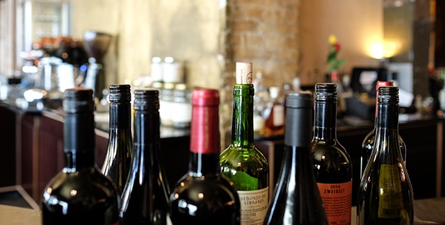 A group of wine bottles on a restaurant counter.