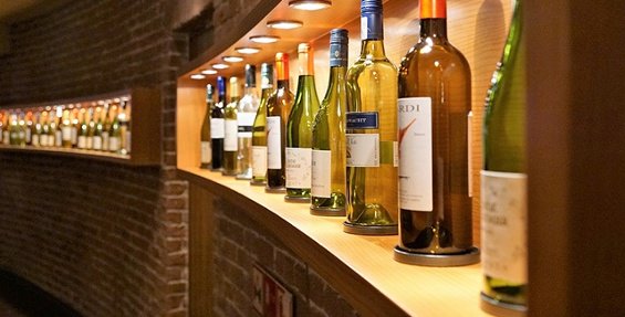A line of wines on a display shelf.
