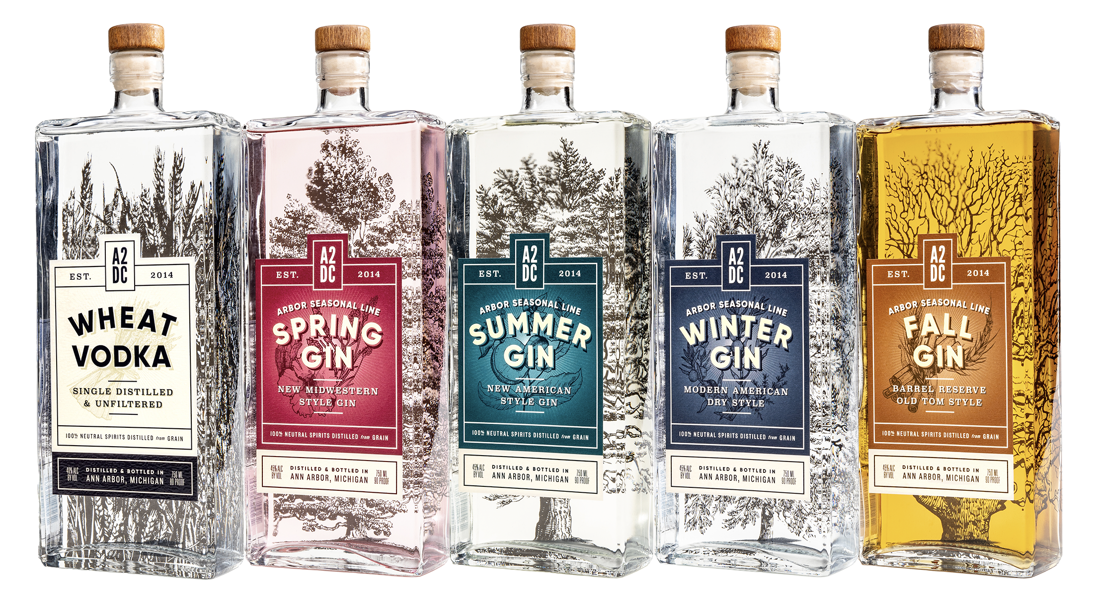 Five clear, rectangular bottles are labeled Wheat Vodka, Spring Gin, Summer Gin, Winter Gin, and Fall Gin, each with distinct seasonal label colors and tree illustrations.