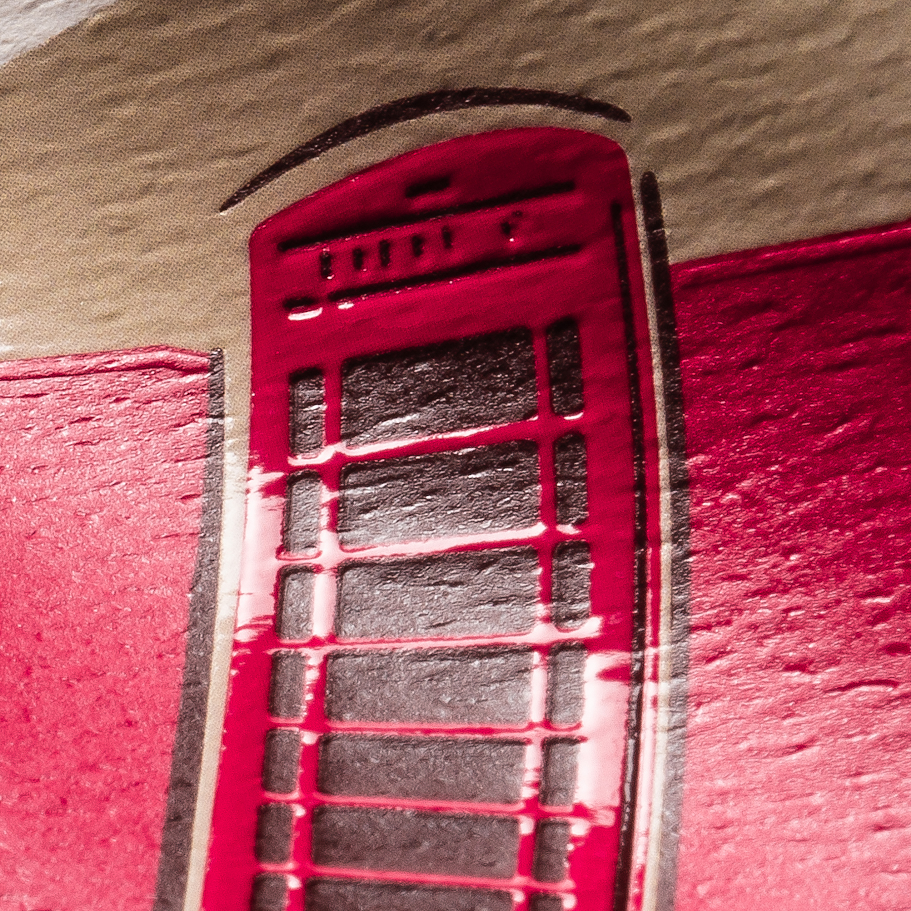 Close-up of red tactile varnish detail on a premium wine label